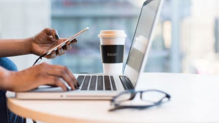 Person using a laptop and phone